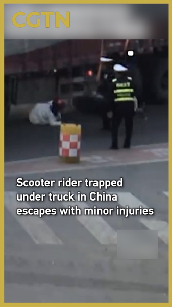 Electric_scooter_rider_trapped_under_truck_in_Chinese_mainland_escapes_with_minor_injuries video poster
